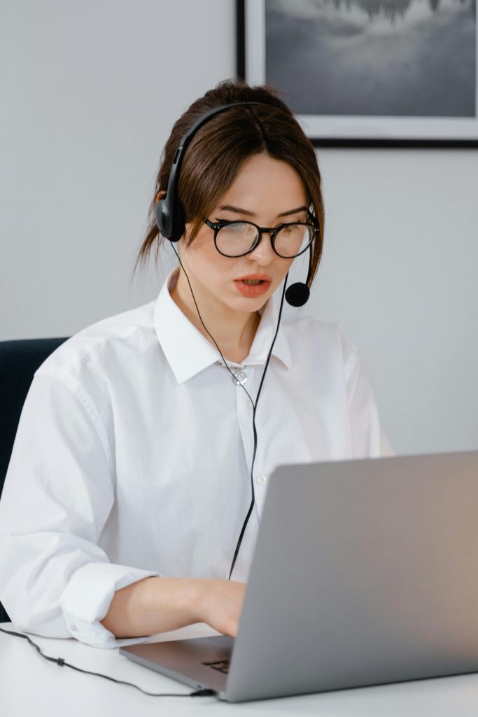 Professional woman in headset working on customer support in an office setting.